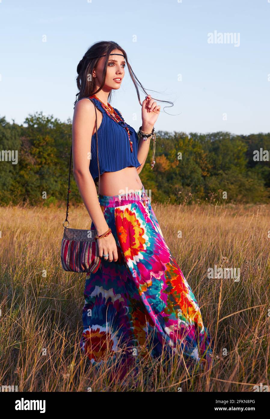 Outdoor portrait of the charming young boho (hippie) girl in meadow at  sunset time Stock Photo - Alamy