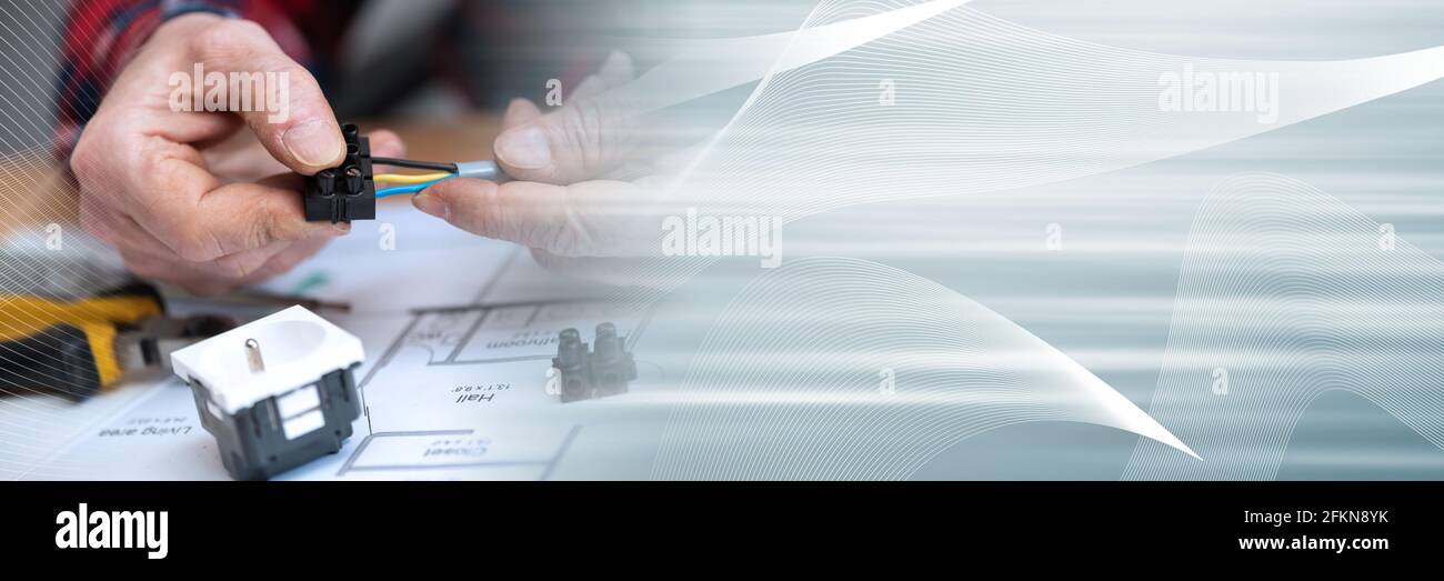 Electrician hands connecting wires in terminal block; panoramic banner Stock Photo