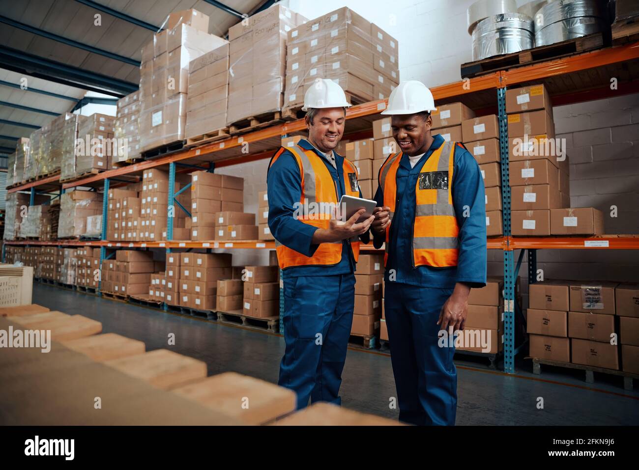 Happy colleagues discussing something using digital tablet Stock Photo