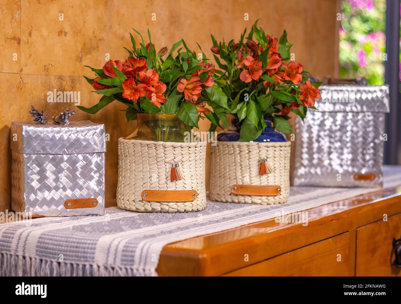 Aluminum boxes and decorative handmade vases with red alstroemeria flowers in the living room