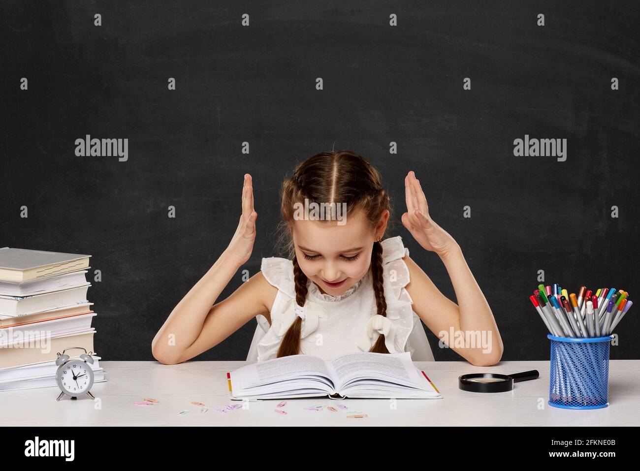 little child girl reading a book in the classroom Stock Photo