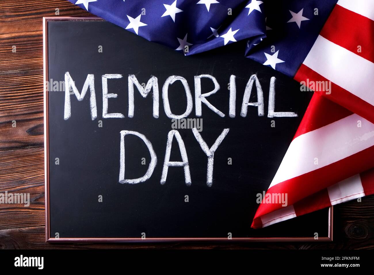 Memorial day weekend text written on wooden black chalkboard with USA flag. United States of America stars & stripes patriot veteran remembrance symbo Stock Photo