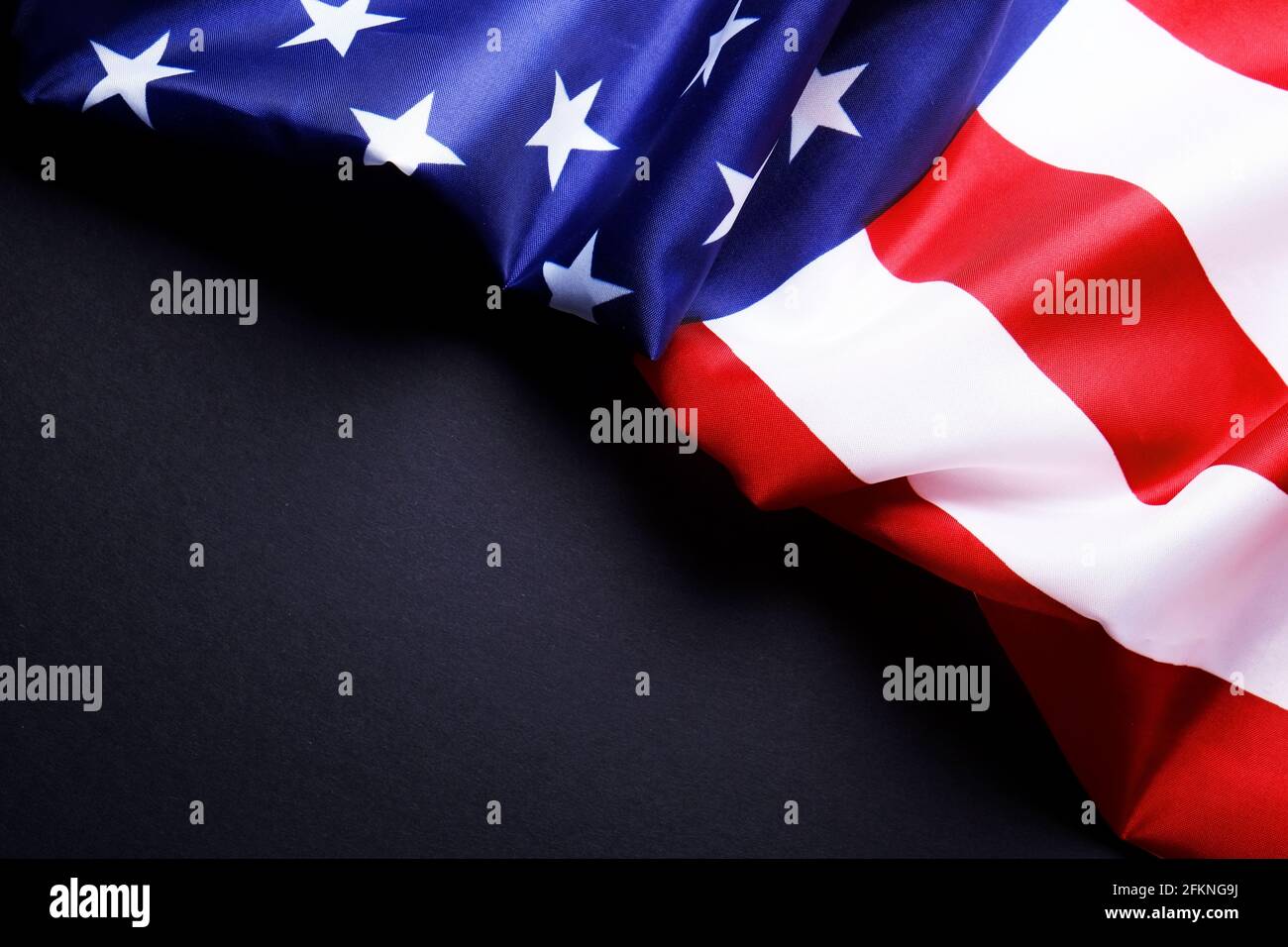 Patriotic composition w/ ruffled American flag on black background ...