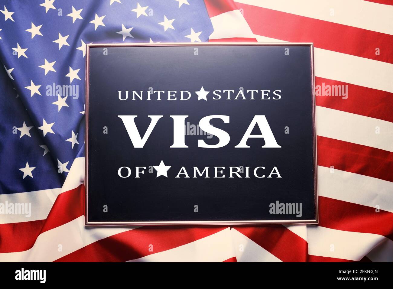 Close up of black chalkboard with UNITED STATES OF AMERICA VISA text written on it. Visa application formalization concept. Ruffled USA American flag Stock Photo