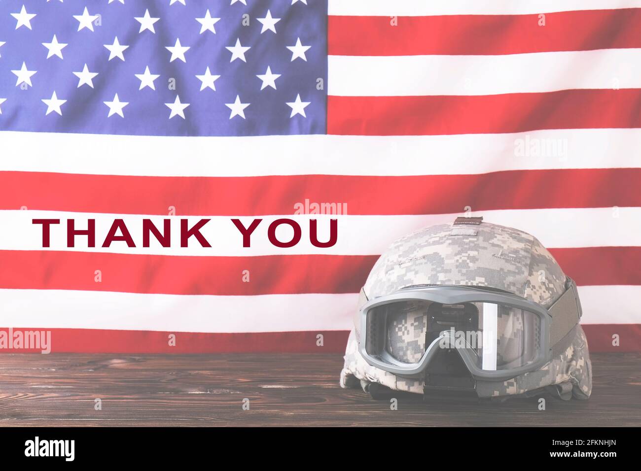 Thank you text. US Army kevlar combat helmet, camo cover, tactical goggles, USA flag background. Memorial day weekend, United States of America armed Stock Photo