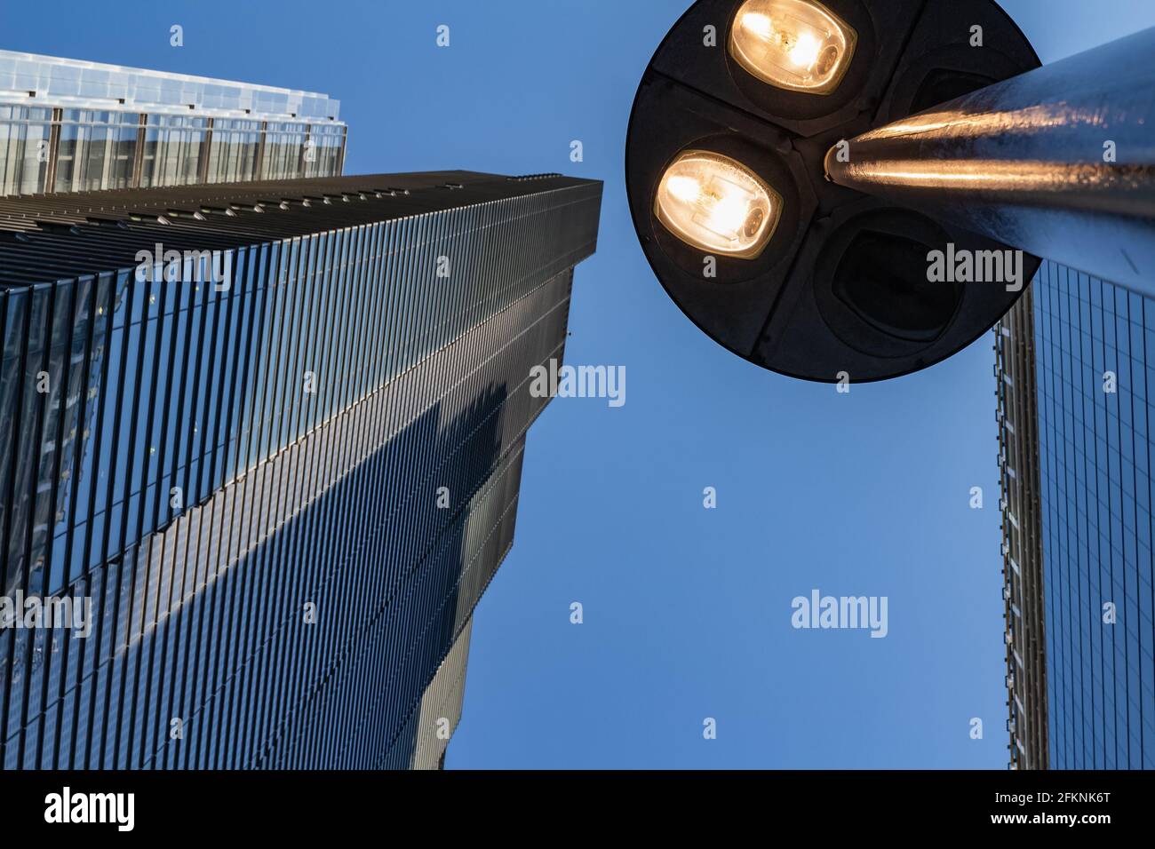Windows of skyscraper business office building with street lamp at front, Corporate buildings in city. Stock Photo