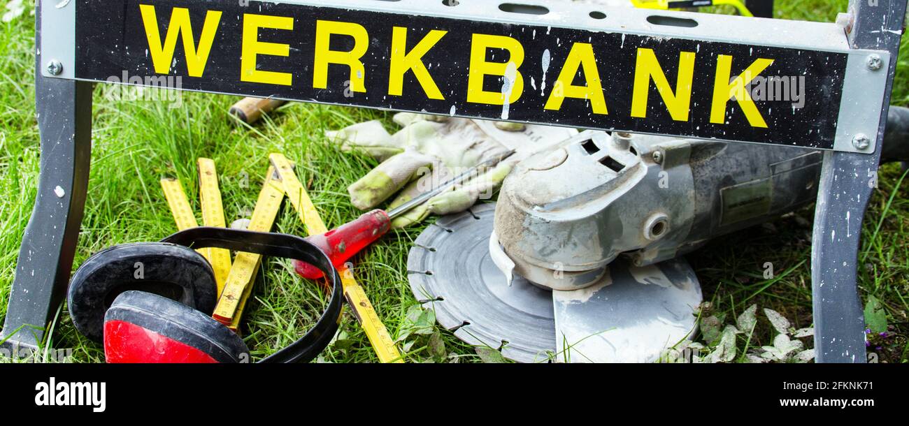 Werkbank im Garten mit Winkelscheifer, Flex und Zubehör Banner Stock Photo