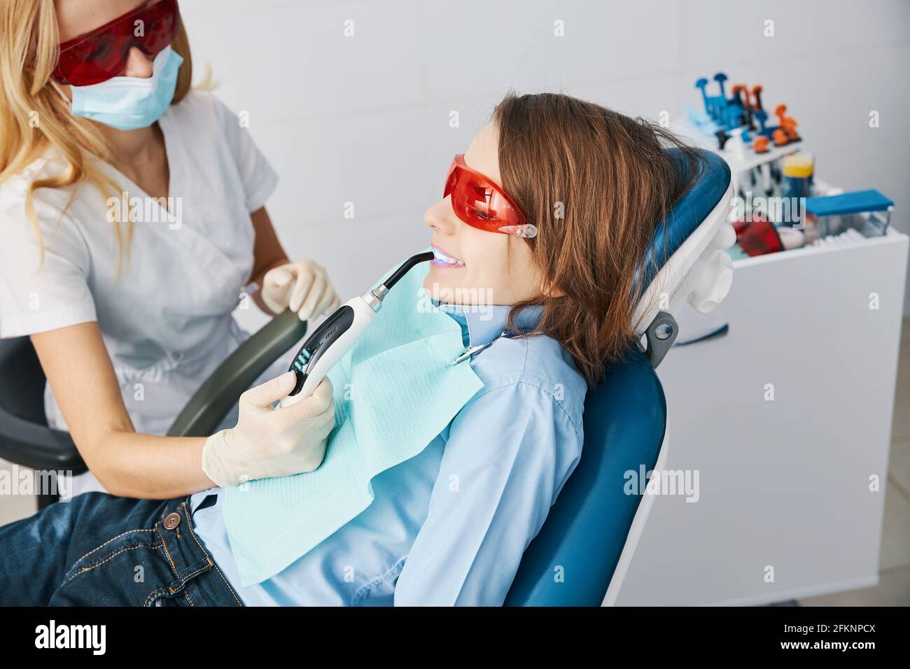 Doctor and patient in safety glasses during curing lights treatment