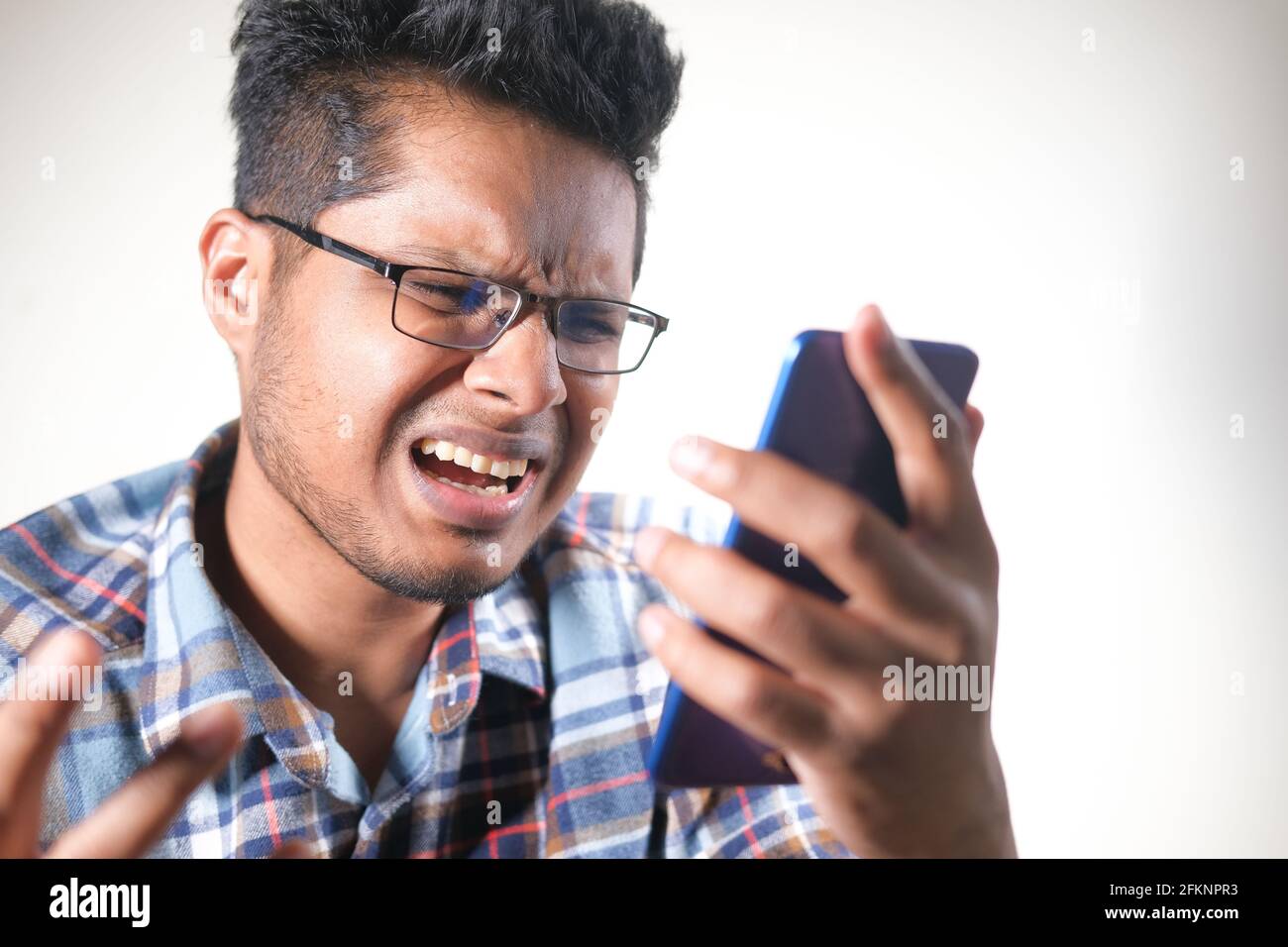 sad young man using smart phone indoor  Stock Photo