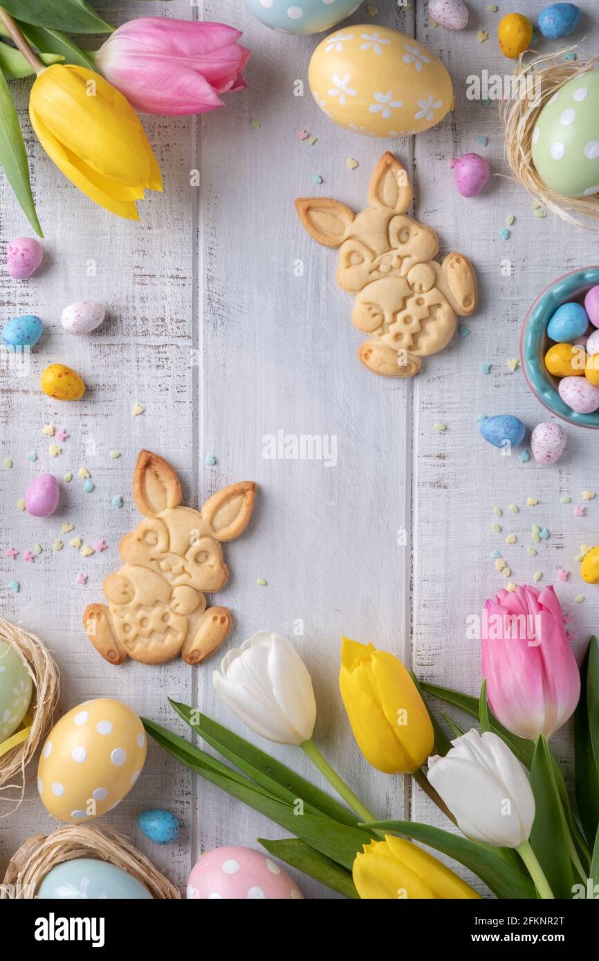 Happy easter background with bunnies eggs candies flowers Stock Photo