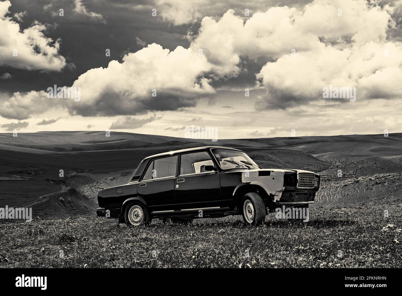 Old abandoned car in the field. Retro toned photo Stock Photo