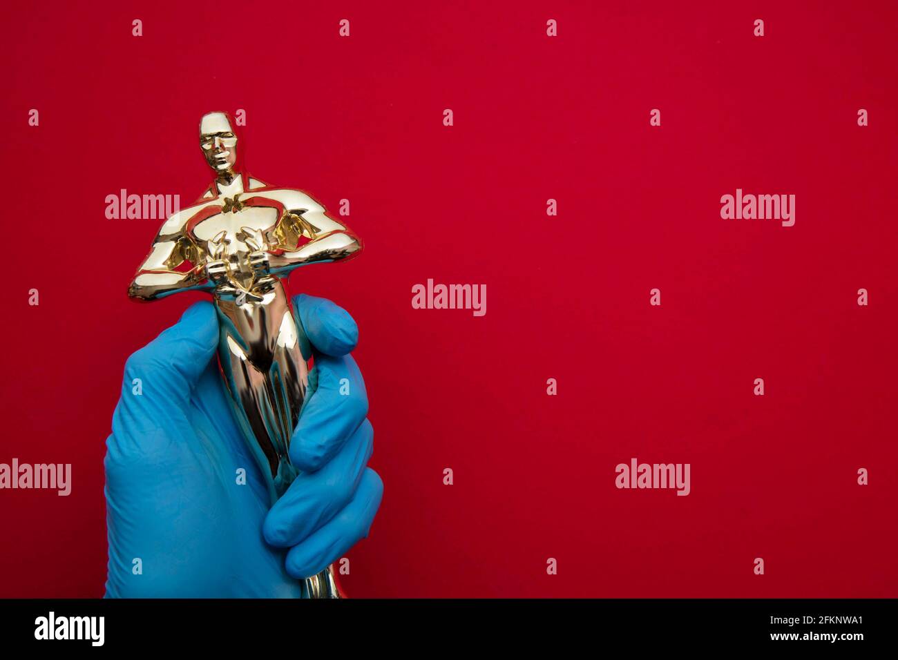 Movie and entertainment award held by someone wearing protective gloves Stock Photo