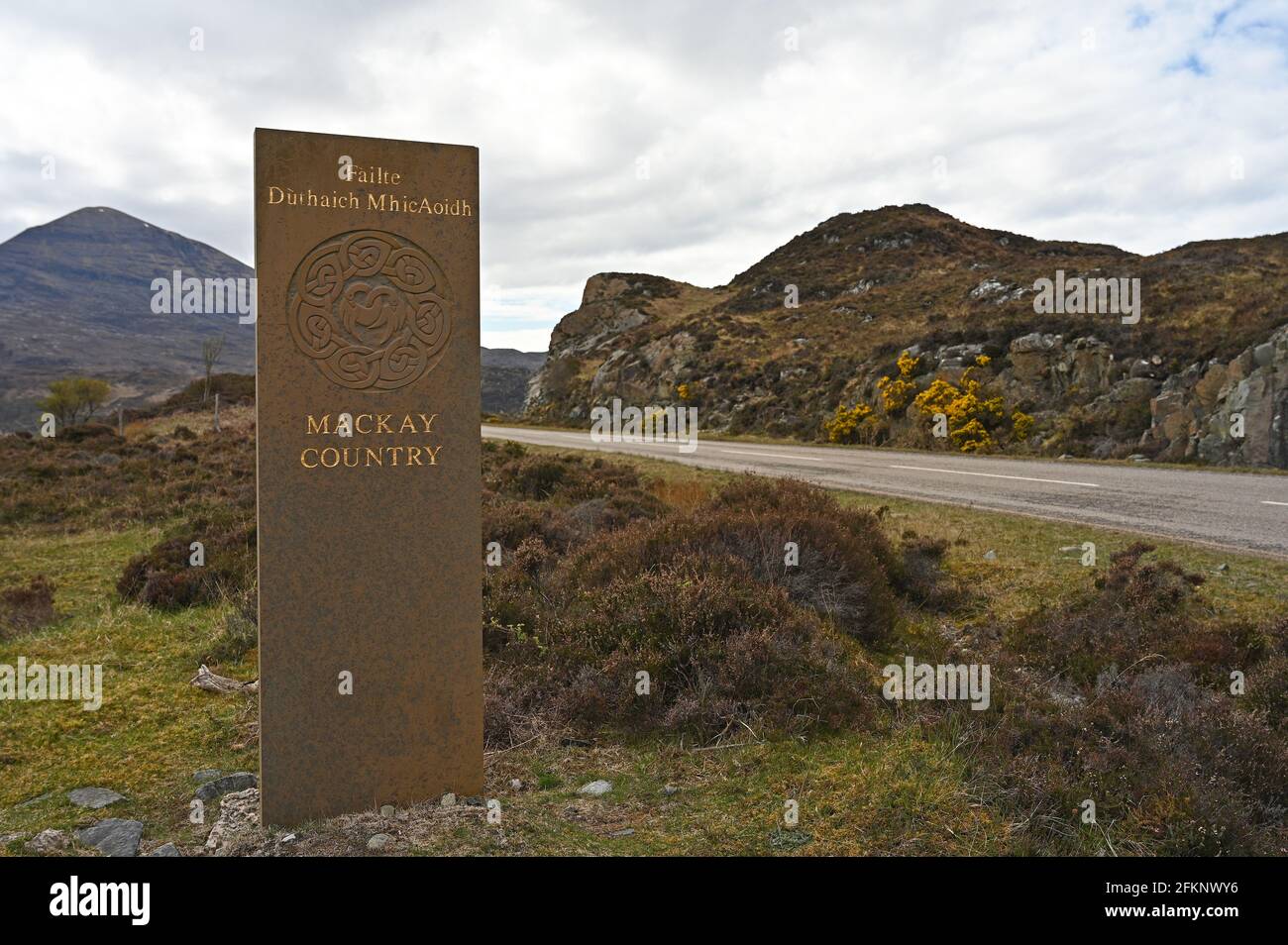 Sign for Mackay Country with blurred background of road and mountains