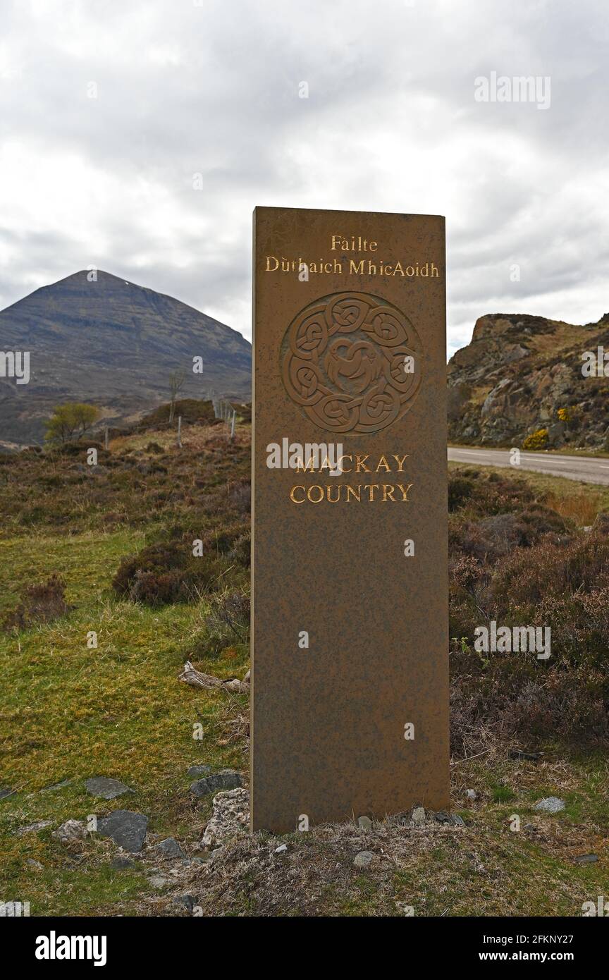 Sign for Mackay Country with blurred background of road and mountains