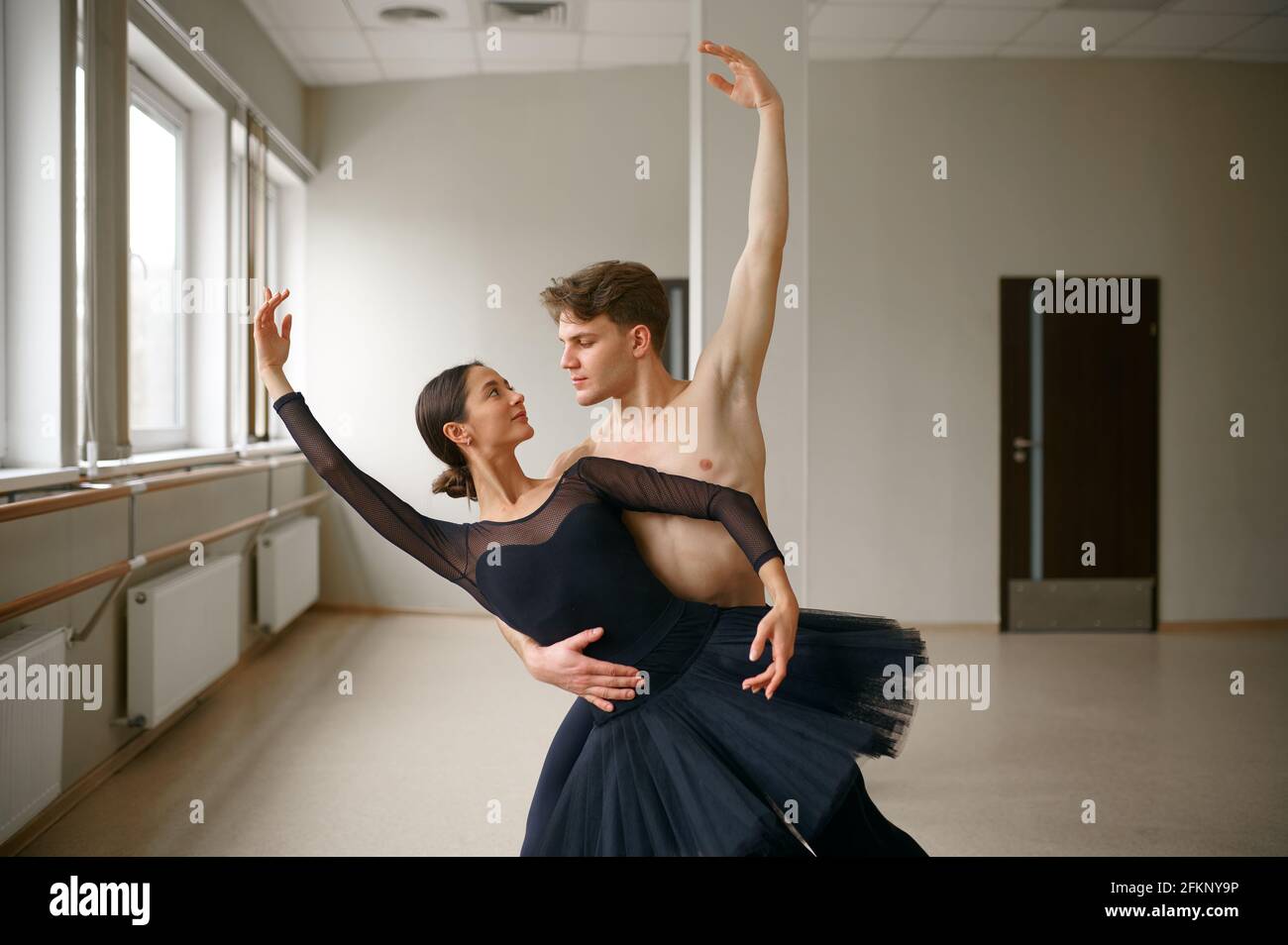 Female and male ballet dancers dancing at barre Stock Photo