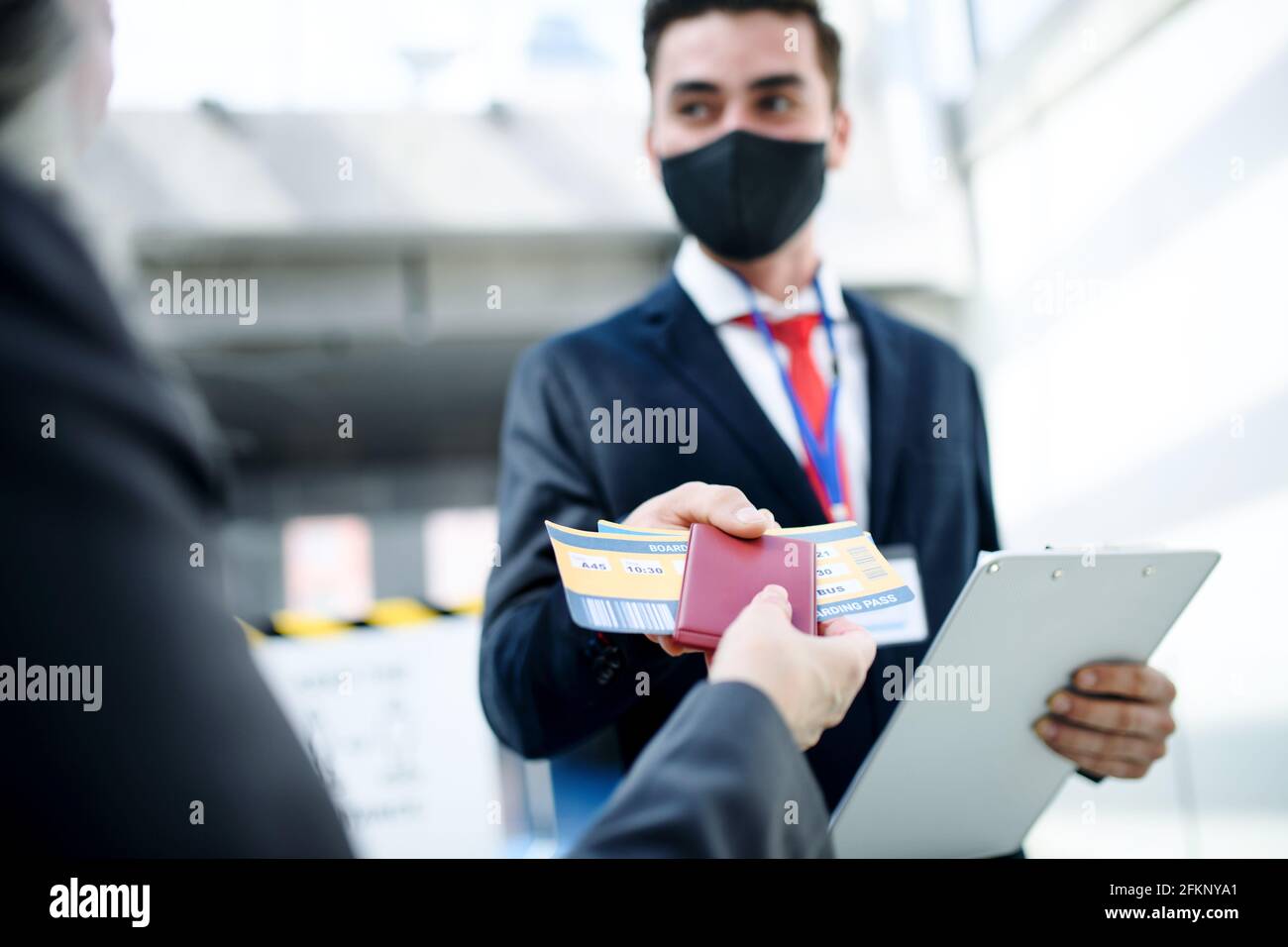 Senior woman with boarding pass at the gate in airport, coronavirus