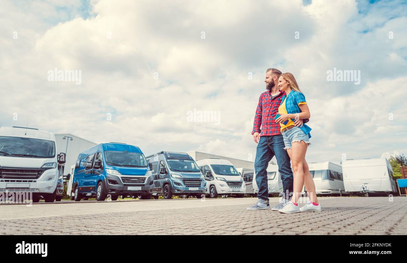 Woman and man choosing camper van to rent or buy Stock Photo