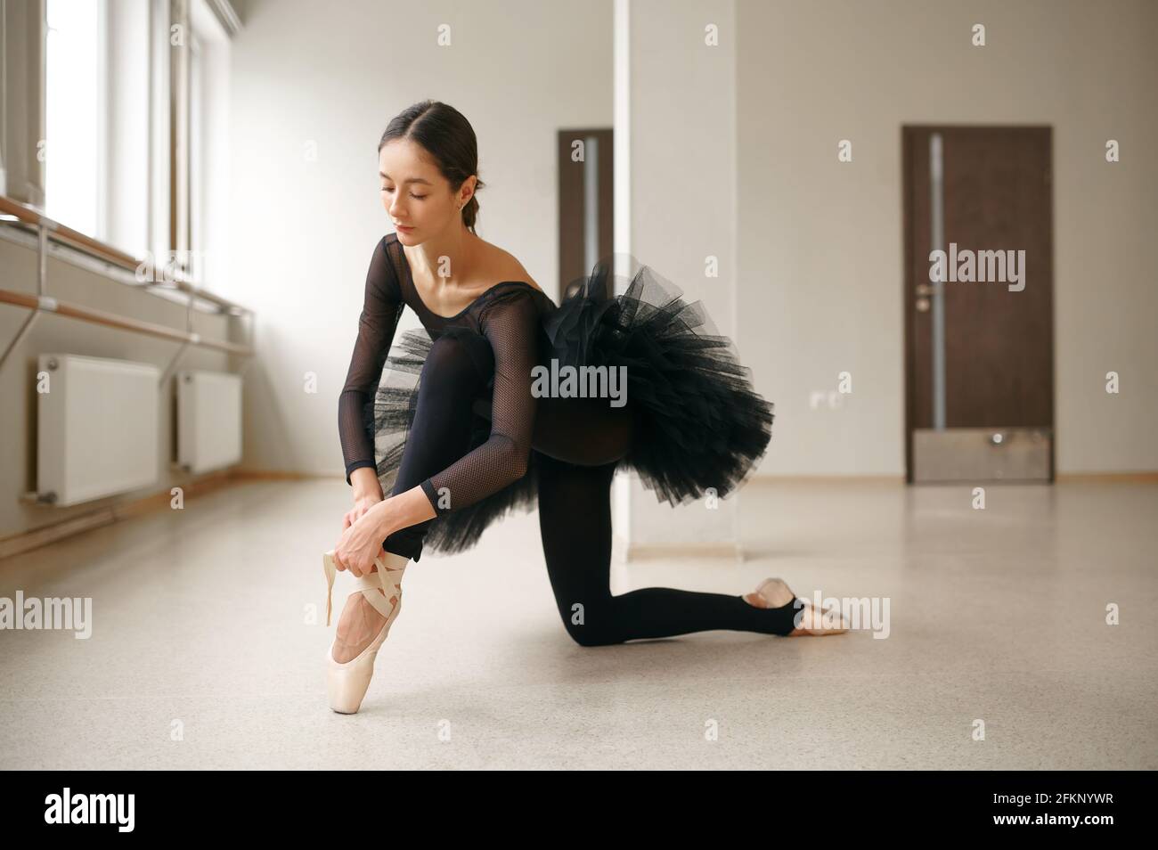 Ballerina doing stretching exercise in class Stock Photo