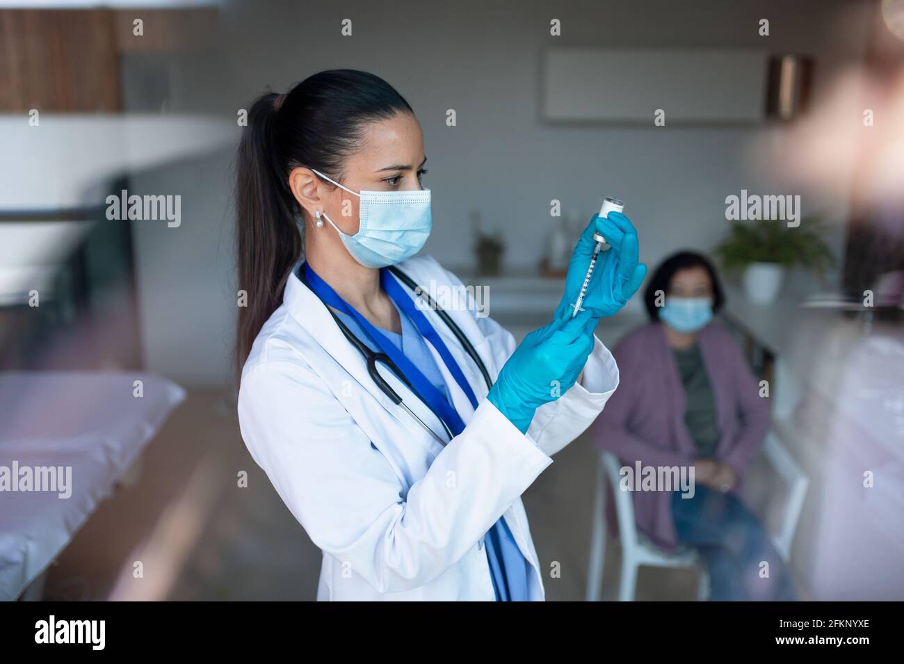 Portrait of woman doctor with syringe standing in hospital, coronavirus concept. Stock Photo