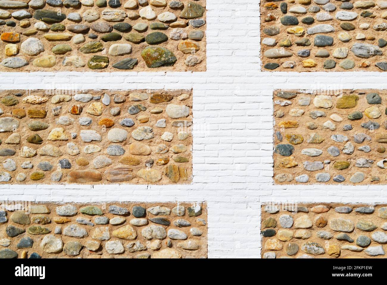The surface of a massive wall, built with a mixed material choice (stone and brick) and rustical texture. Stock Photo