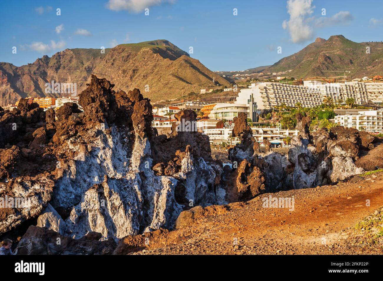 Tenerife Island landscape with volcanic coastal rocks and town of Los ...