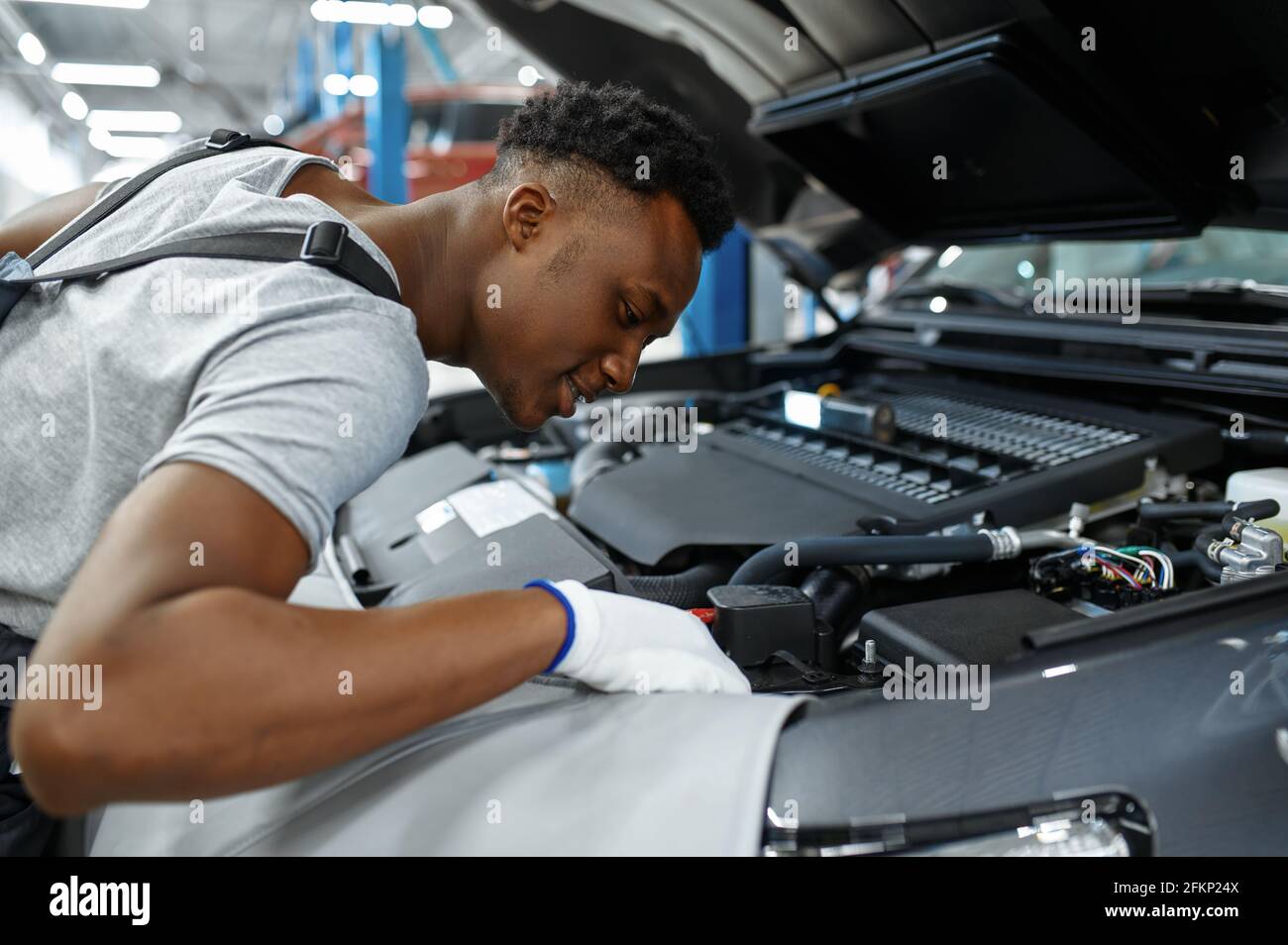 Male mechanic checks engine, car service Stock Photo - Alamy