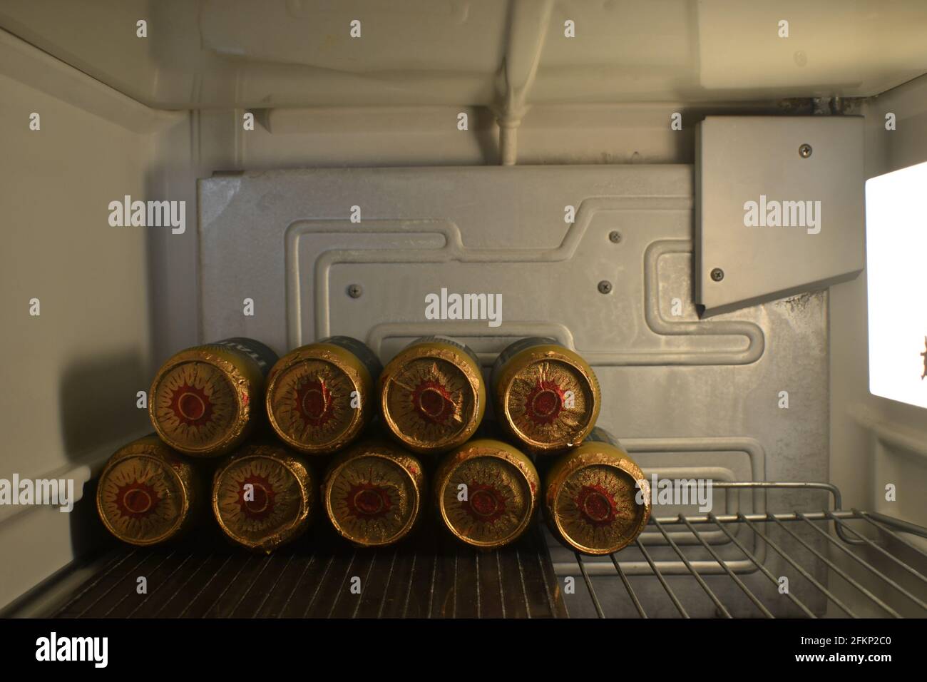 Beers in the refrigerator, open vintage refrigerator showing the inside with internal light and shelf with cans of cold beers Stock Photo
