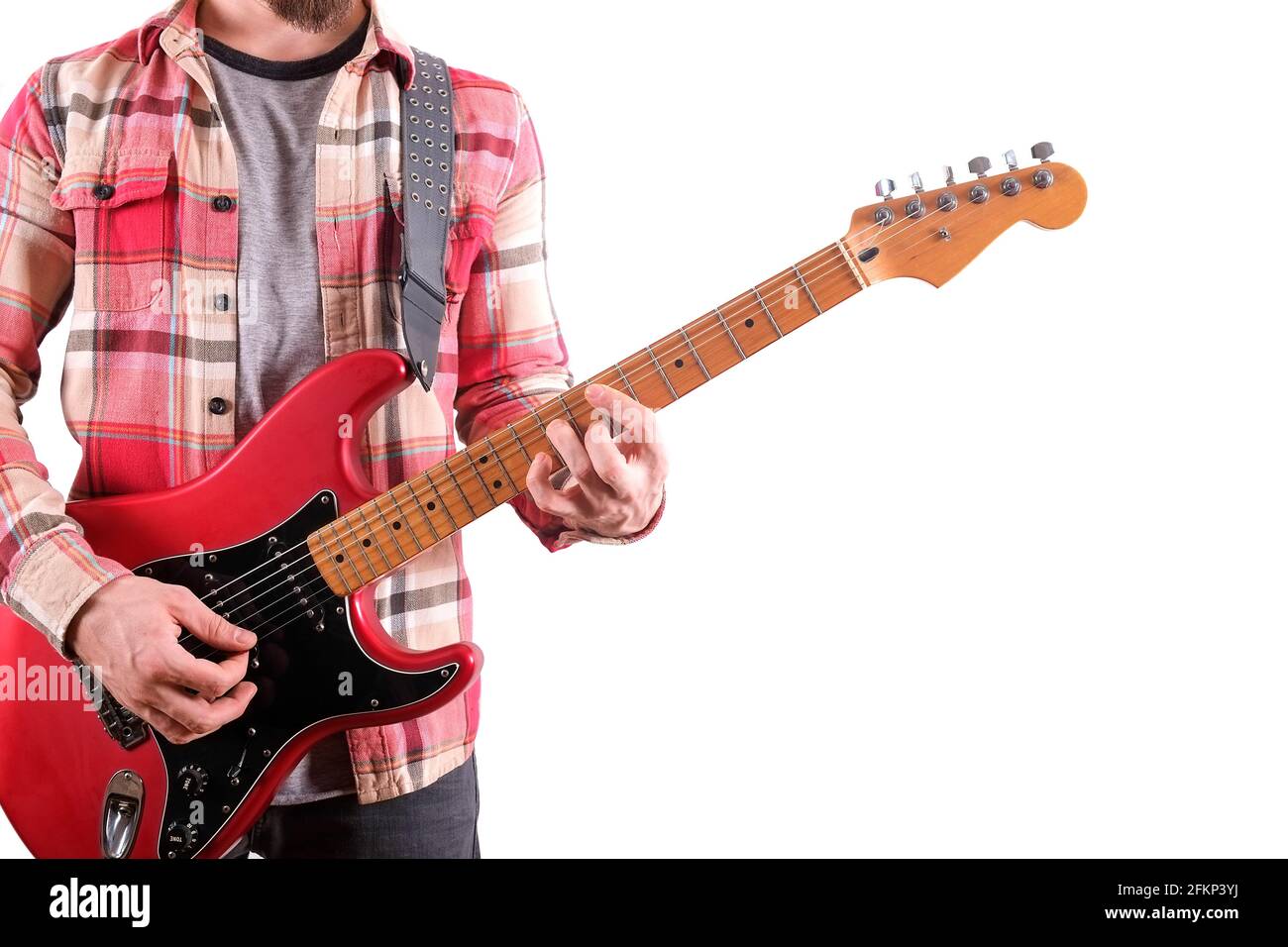 Rock guitarist in checkered plaid shirt playing candy apple red electric guitar w/ single coil, maple neck & black pickguard. Man holding musical inst Stock Photo
