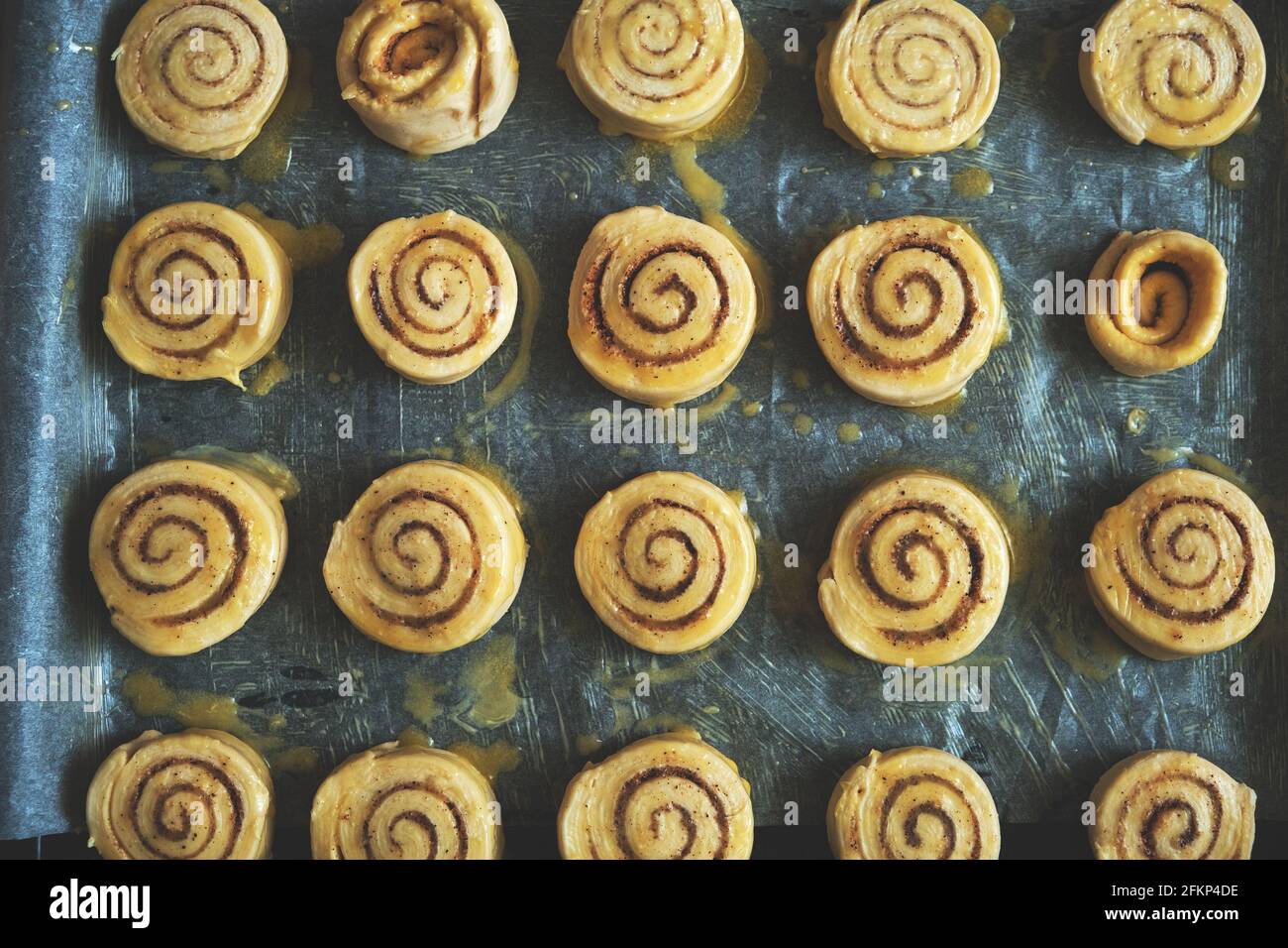 Blanks for baking cinnamon rolls on baking sheet with parchment paper Stock Photo