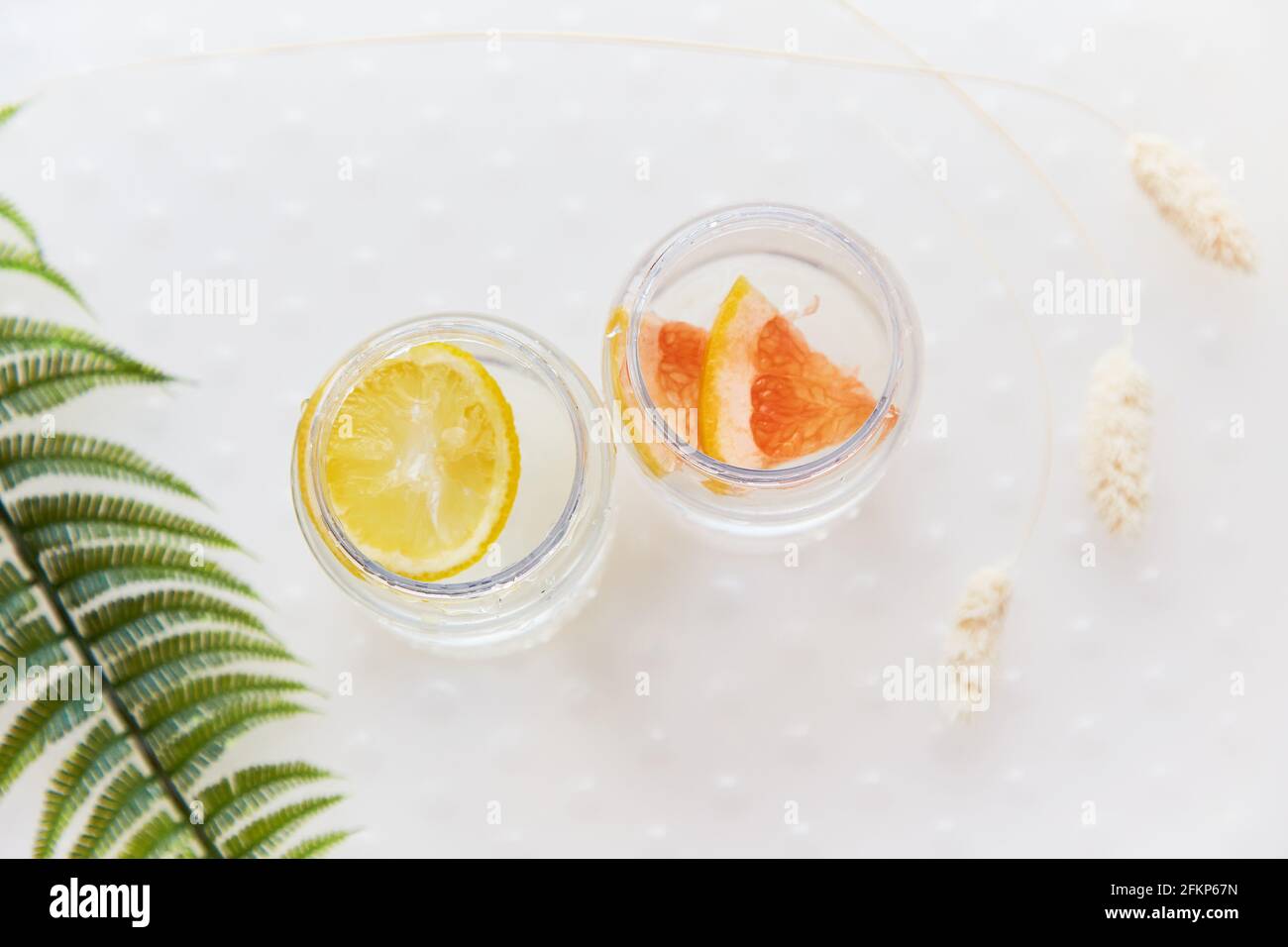Handmade summer drinks with tropical flowers. Hard seltzer with lemon and grapefruit. Homemade summer cocktails concept on white background. High quality photo Stock Photo