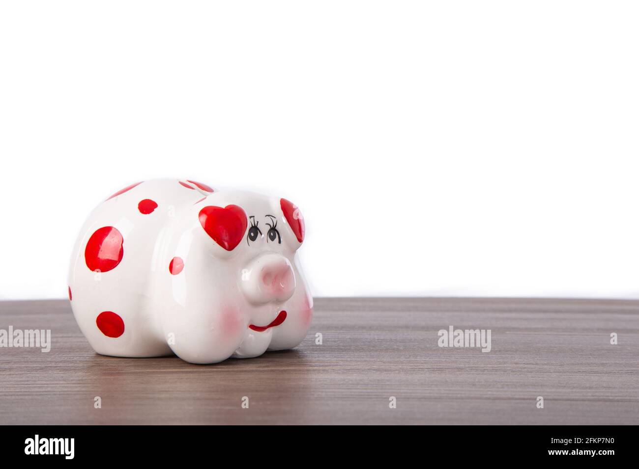 Cute piggy bank on wooden table with white background Stock Photo - Alamy