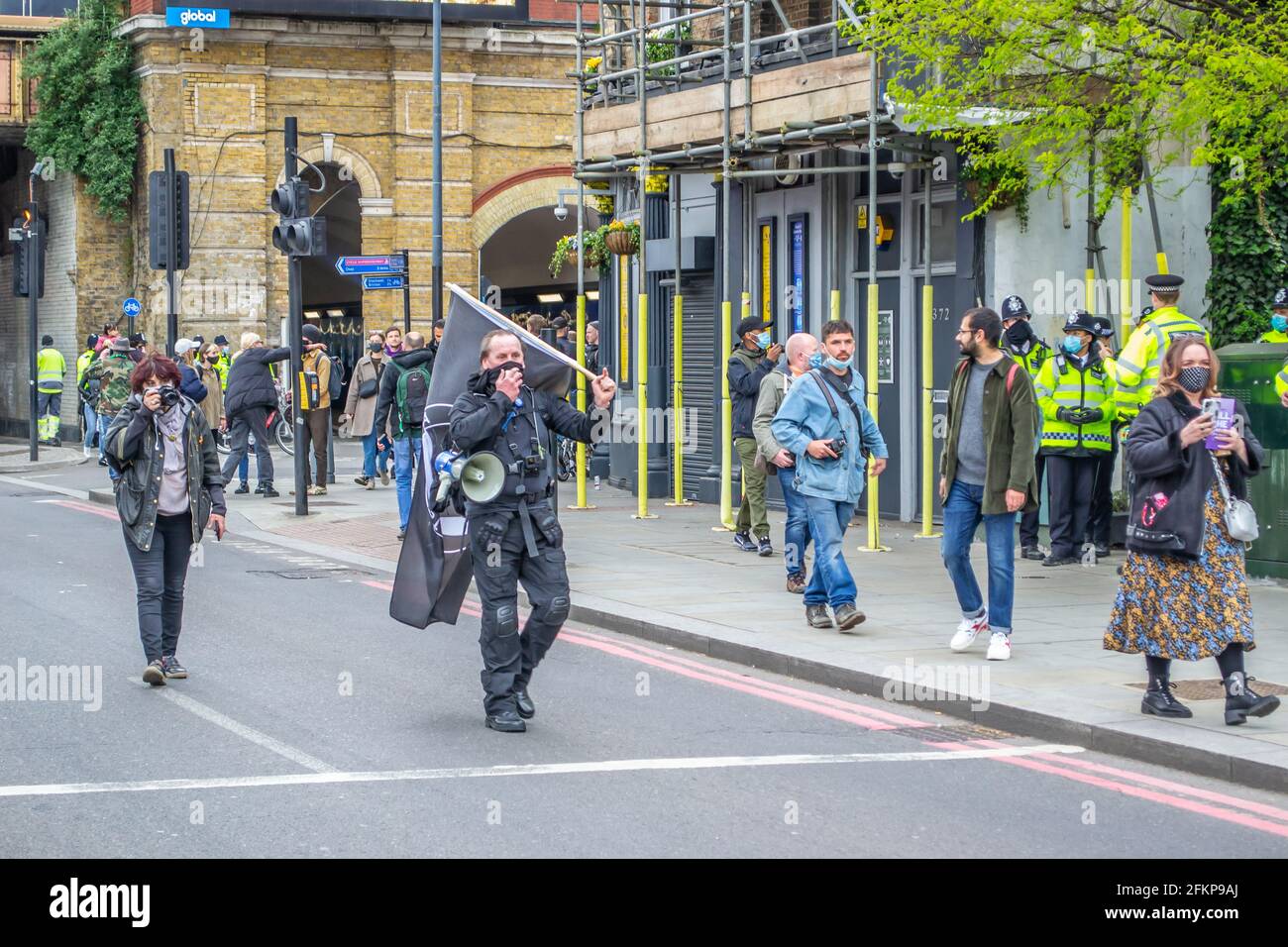 VAUXHALL, LONDON, ENGLAND- 1 May 2021: Protester carrying an ANTIFA ...