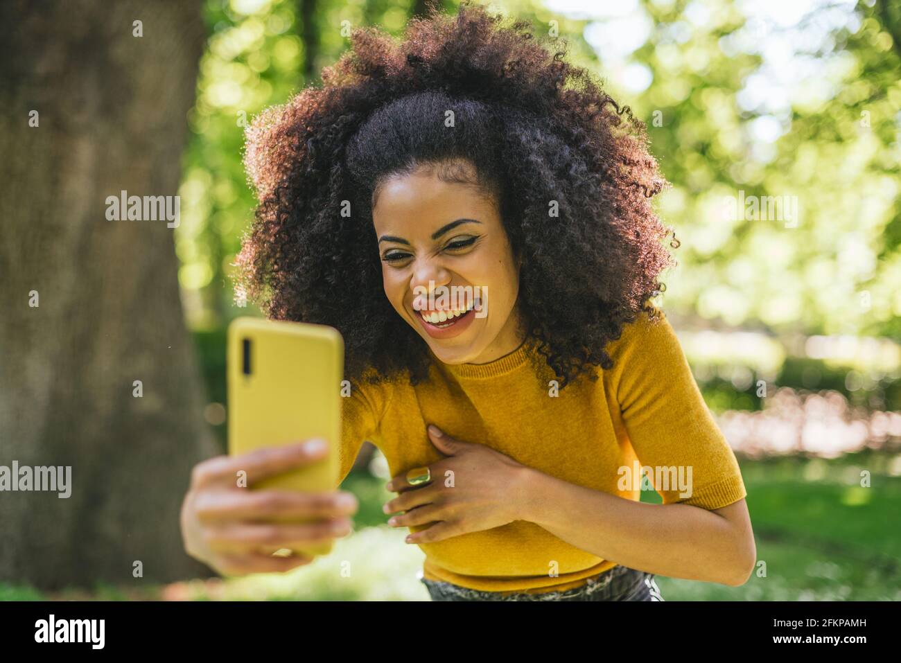 Pretty afro girl taking a selfie laughing. Stock Photo