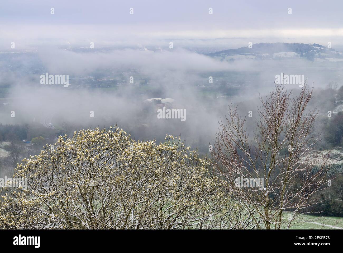 Birdlip, Cotwolds, Gloucestershire, UK with mist and snow in April. View across the Avon Valley. Stock Photo