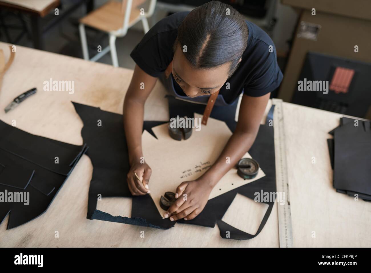 African female artisan working with leather in her studio Stock Photo ...