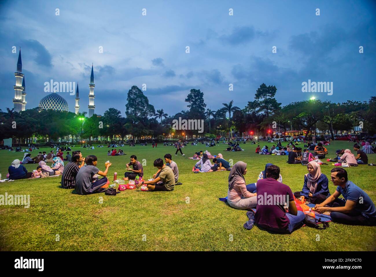 Kuala Lumpur, Malaysia. 27th Apr, 2021. Malaysian Muslims breaking fast as they practice social distancing during Ramadan in a field in front of Shah Alam mosque. The public has been urged to continue adhering to the standard operating procedures (SOPs) during breaking of fast event to curb the spread of coronavirus. (Photo by Vivian Lo/SOPA Images/Sipa USA) Credit: Sipa USA/Alamy Live News Stock Photo