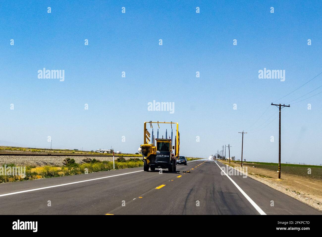 A Harobed machine navigates down Highway 33 in the Central Valley of California USA named for the inventors daughter Deborah Stock Photo