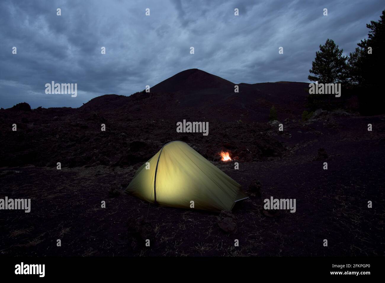 wild camp illuminated tent at evening in Sicily nature of volcanic landscape of Etna Park natural landmark of sicilian tourism Stock Photo
