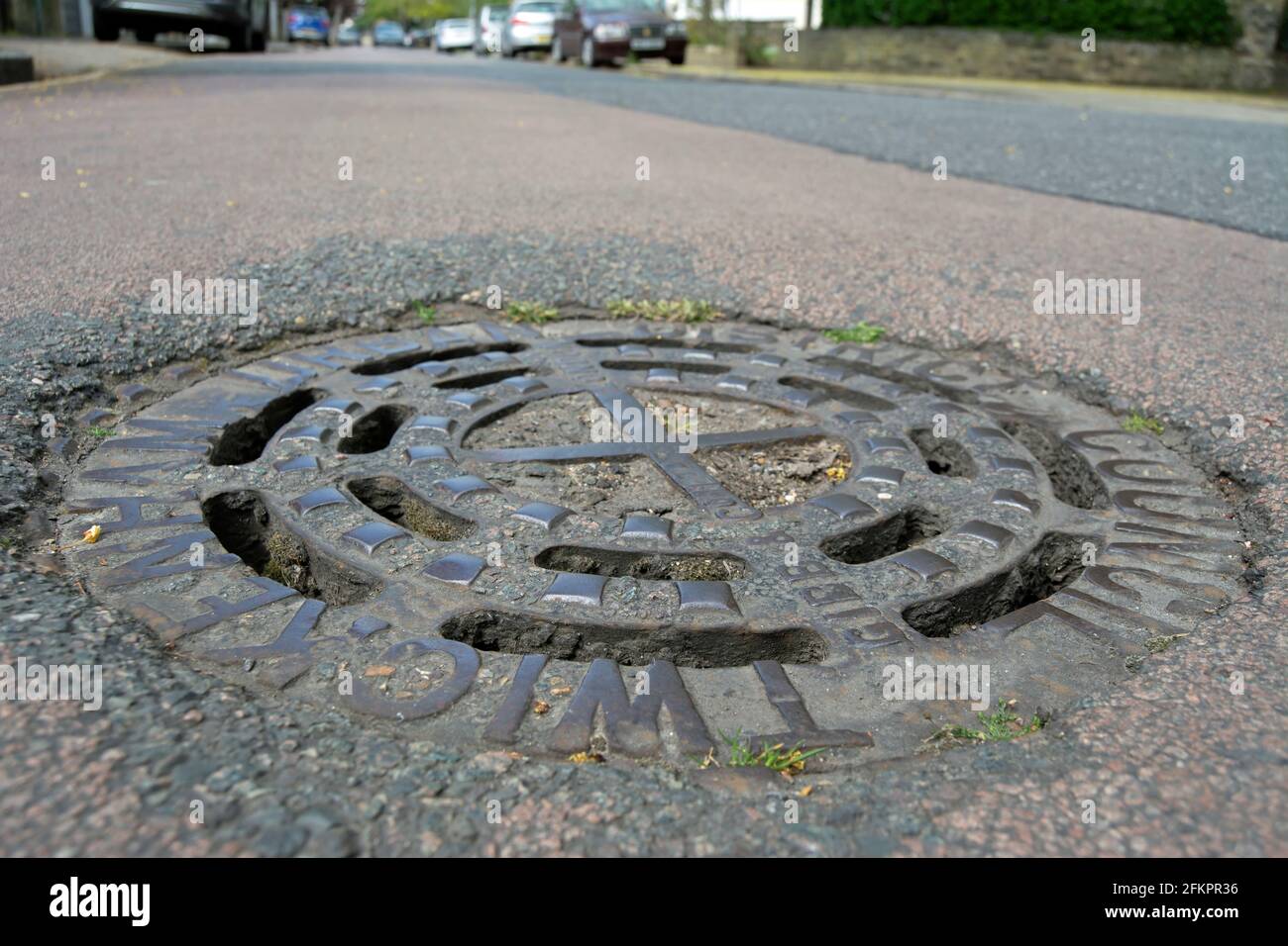 pre-1965 manhole cover, or drain cover, in twickenham, middlesex, england, bearing the name of twickenham urban district council Stock Photo