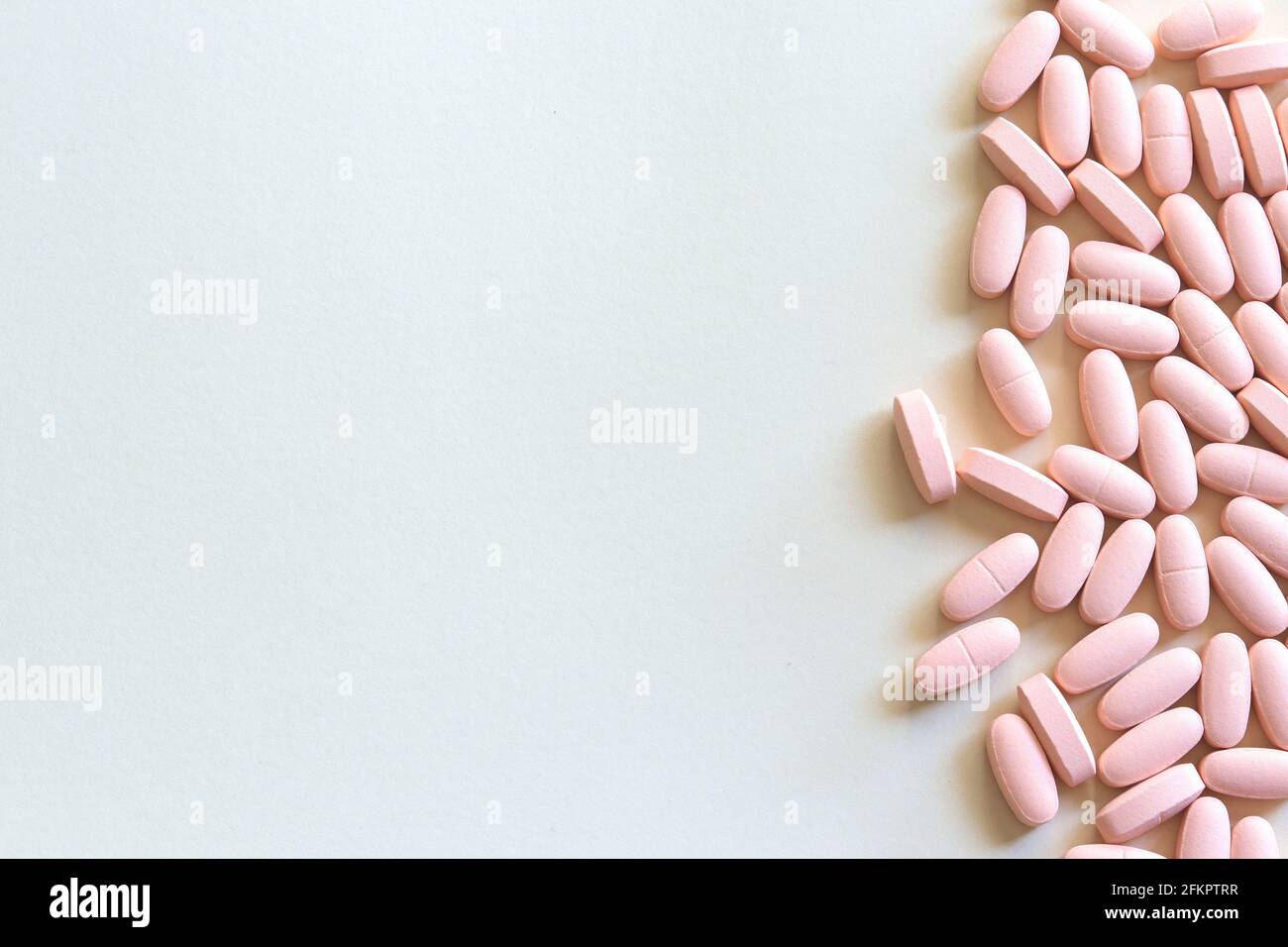 Pink pills on grey background with space for text Stock Photo