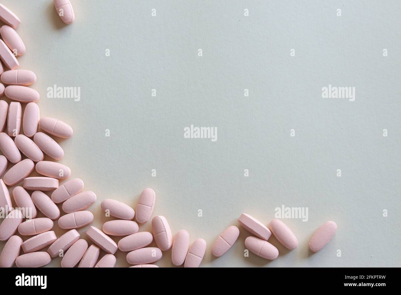 Pink pills on grey background with space for text Stock Photo