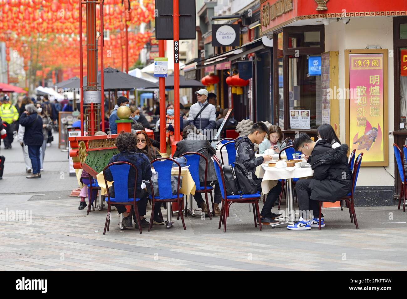 London, England, UK. Chinatown - people eating outside in Gerrard Street Stock Photo