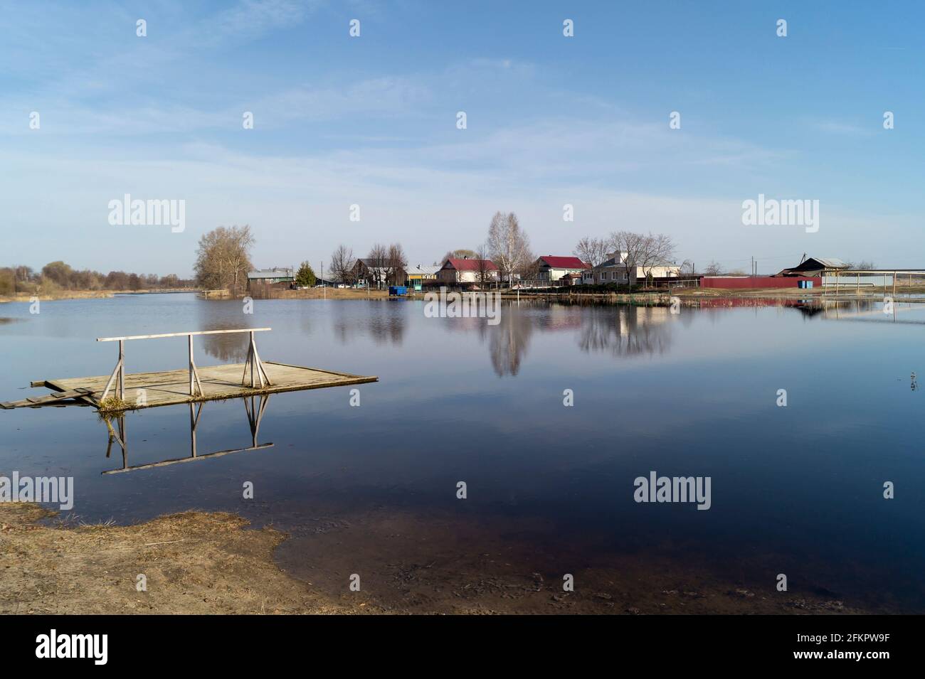 Spring flood in the countryside against a blue sky with white clouds. Beautiful landscape on a sunny day in Russia Stock Photo