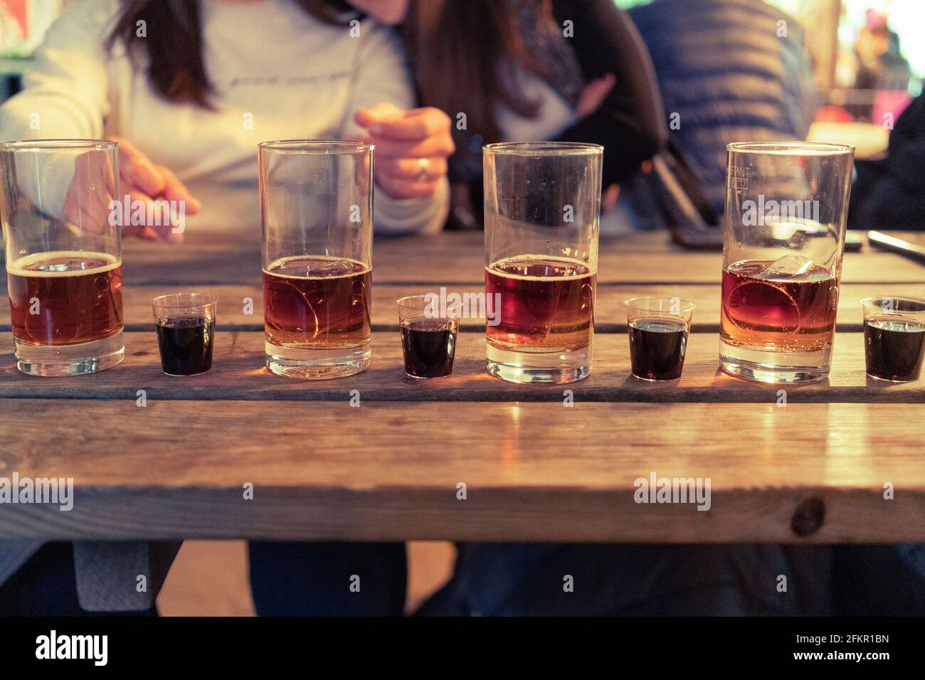 Pubs reopening post Covid-19 lockdown - Jägerbombs & black sumbuca shots on a wooden table outside Barton's Mill pub in Old Basing, UK. May 2021 Stock Photo