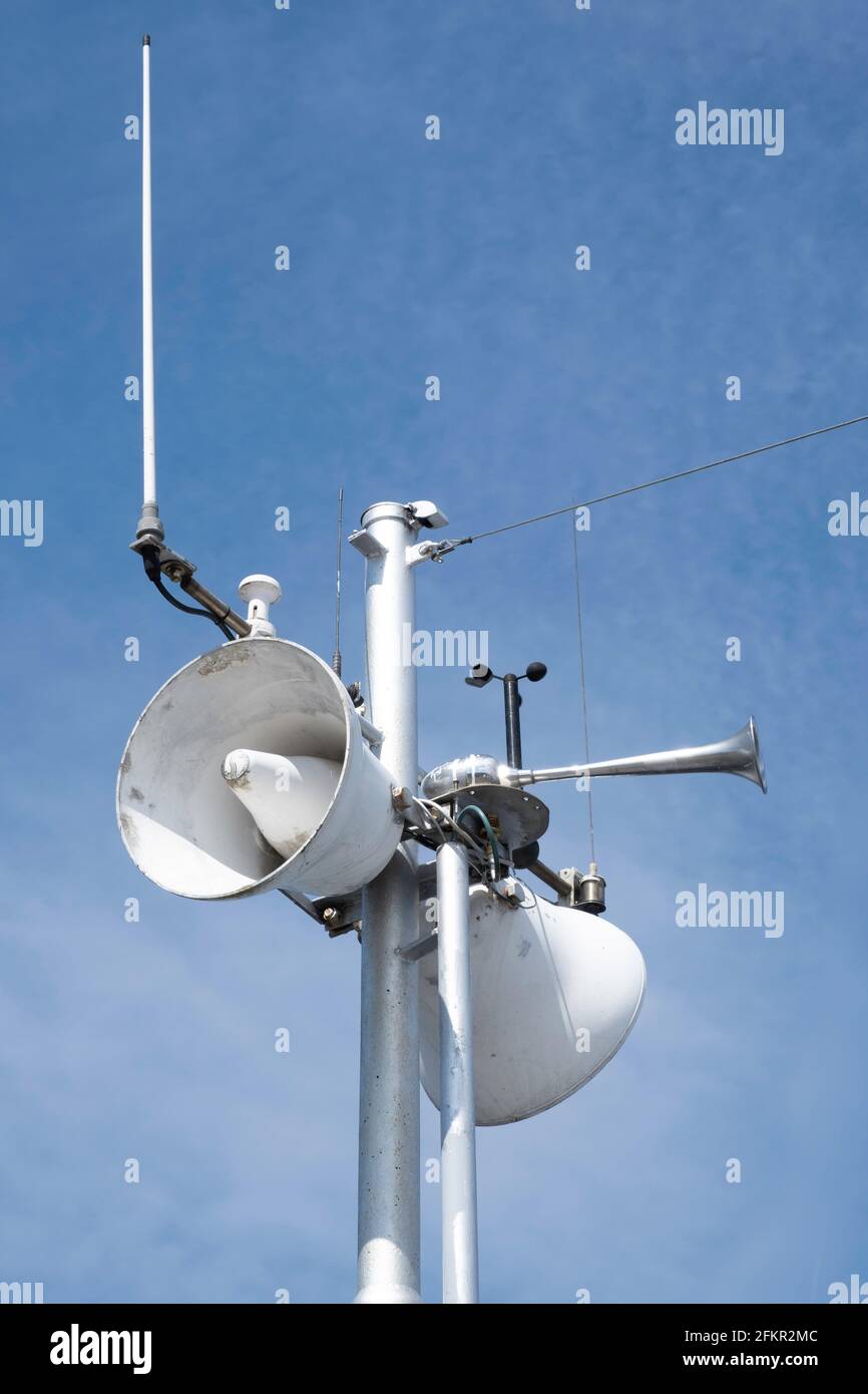 Views of a horn, antenna and navigation system in white metal in the mast of a ship with a blue sky in the background, on a sunny day Stock Photo