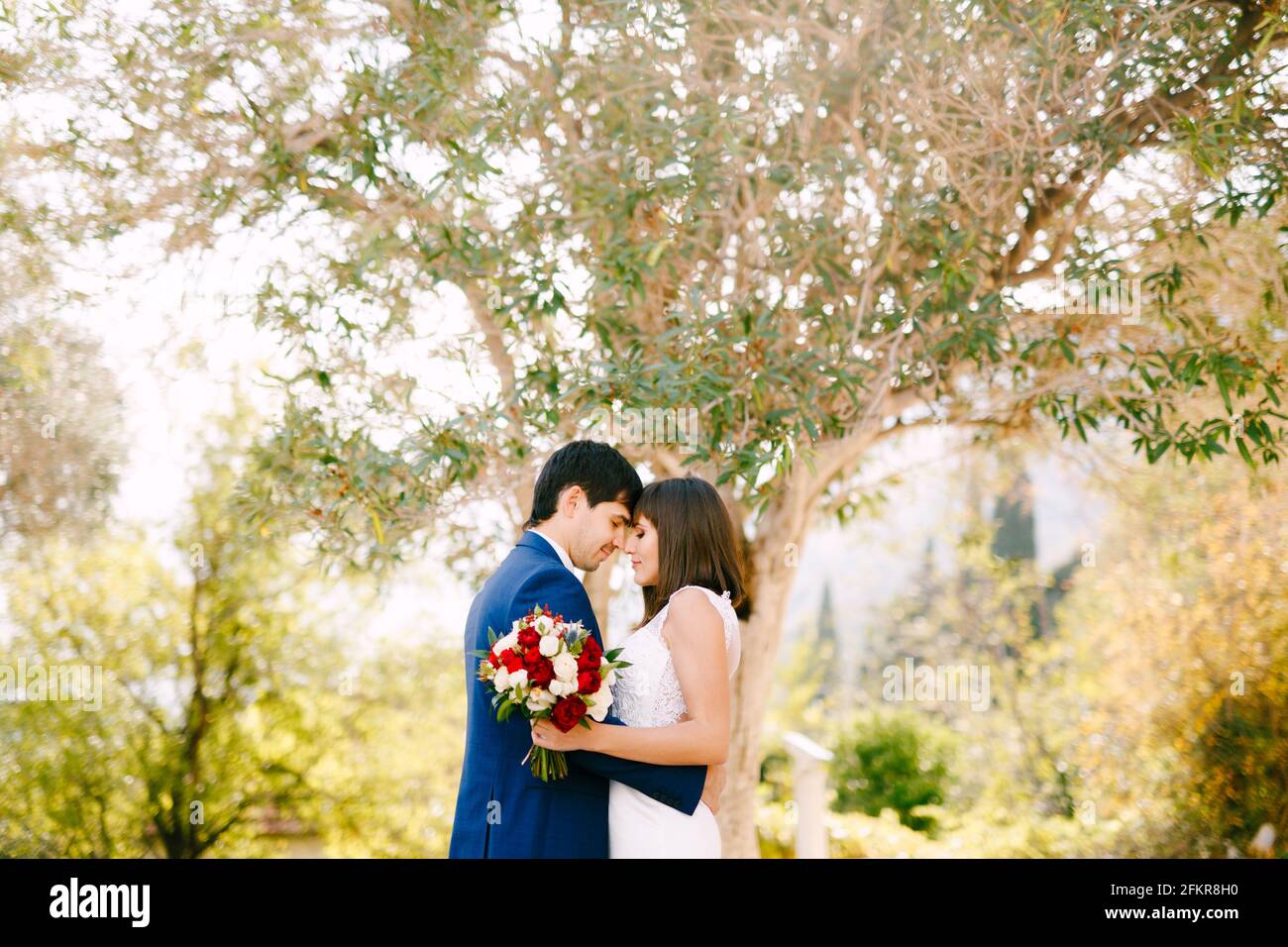 Bouquet red roses couple hugs hi-res stock photography and images - Alamy
