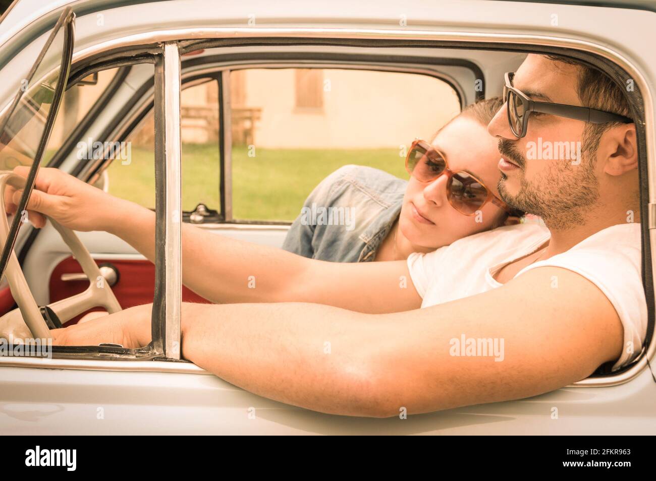 Couple in love having a rest during honeymoon vintage car trip - Hipster lifestyle traveling around the world with classic car Stock Photo