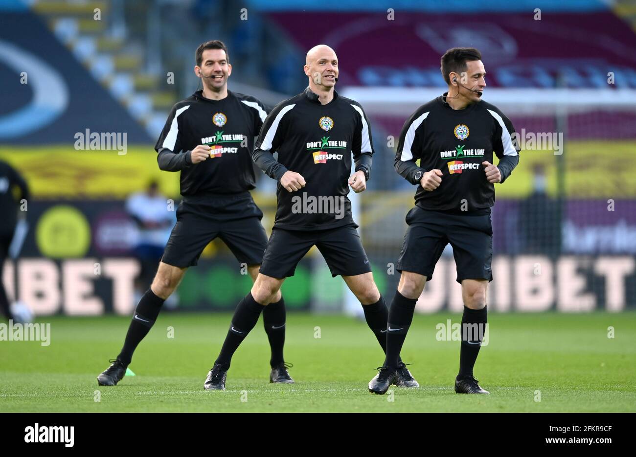 Referee Anthony Taylor (centre) and his assistants wear a 'dont cross the line, refspect' t-shirt before the Premier League match at Tuff Moor, Burnley. Issue date: Monday May 3, 2021. Stock Photo