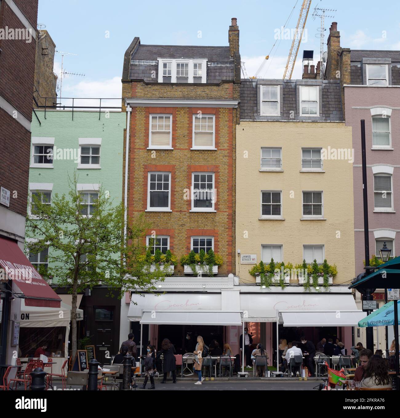 London, Greater London, England - Apr 27 2021: pastel coloured properties with Cafe's on James Street London with people enjoying breakdown easing. Stock Photo