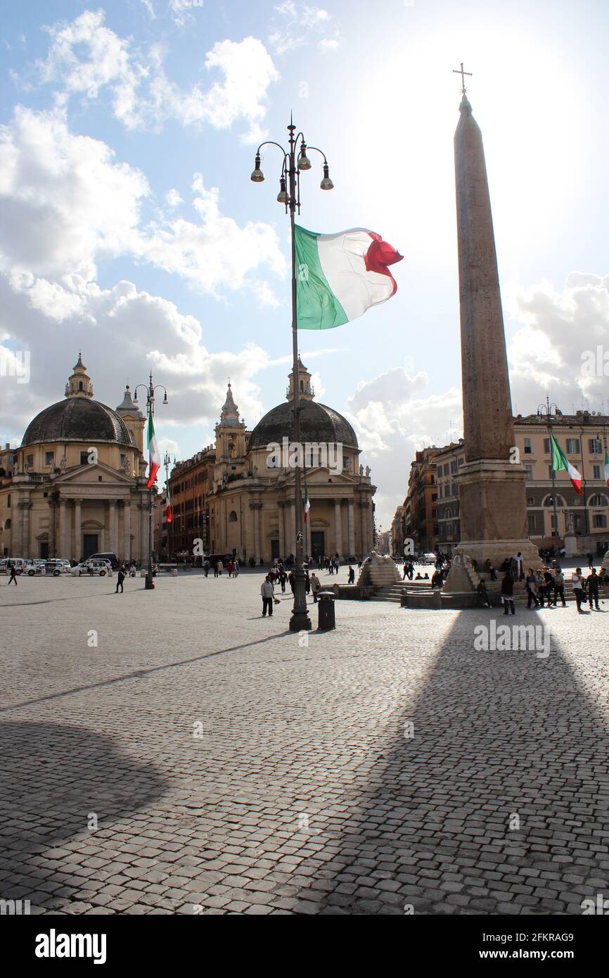 Piazza del Popolo in Rome, Italy. Twin Churches with Obelisk in plaza and giant Italian floag Stock Photo